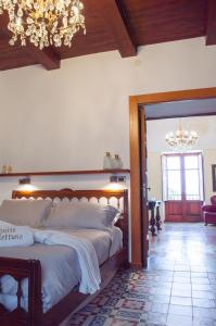 a bedroom with a large bed and a chandelier at Suite Nettuno Paestum in Paestum