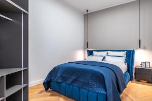 a bedroom with a blue bed with a blue comforter at Z-Suites K7 in Berlin