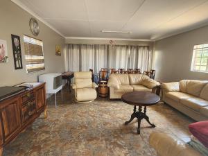 sala de estar con sofás, mesa y sillas en DE JAGTER'S NEST, en Otavi