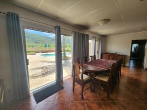a dining room with a table and a large window at DE JAGTER'S NEST in Otavi