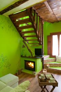 sala de estar con chimenea y paredes verdes en El Planeta Escondido, en Losana de Pirón