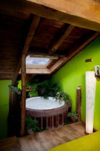 a room with a green wall with a large white tub at El Planeta Escondido in Losana de Pirón