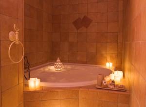 a bathroom with a tub with candles in it at El Planeta Escondido in Losana de Pirón