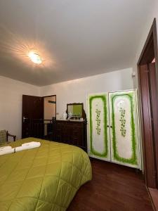 um quarto com uma cama verde e um espelho em Lo Chalet della Principessa em Mormanno