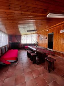 um quarto grande com uma grande mesa de madeira e bancos em Lo Chalet della Principessa em Mormanno