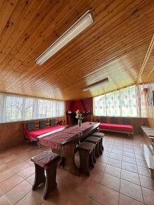 una grande camera con un grande tavolo in legno e panche di Lo Chalet della Principessa a Mormanno