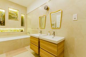 a bathroom with two sinks and a tub and mirrors at Bengt Apartment Kiraly Str. Luxury Suite in Budapest