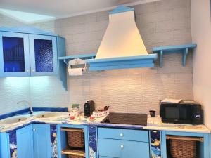 a kitchen with a sink and a microwave at Margiolà Amalfi in Amalfi