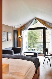 a hotel room with a bed and a balcony at Hotel Zugbrücke Grenzau GmbH in Höhr-Grenzhausen