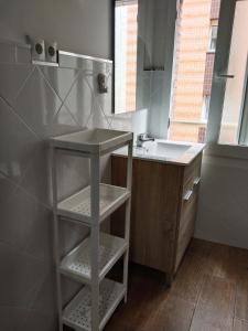 a small bathroom with a sink and a counter at Apartamento Aitue in Gijón