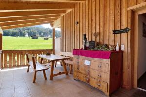 a wooden cabin with a table and a table and chairs at Schererhof Dolomitenblick in Castelrotto