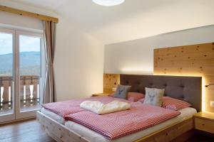 a bedroom with a large bed with a large window at Schererhof Dolomitenblick in Castelrotto