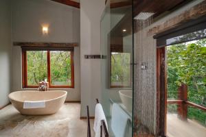 a bathroom with a tub and a sink and a shower at Rhino Ridge Safari Lodge in KwaNompondo