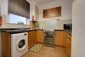 a kitchen with a washing machine and a washer at Home from Home 4-Bed Townhouse - Ideal for Families, Groups & Contractors, Free Parking, Pet Friendly, Netflix in Walkly