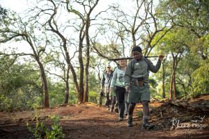 a group of people walking down a dirt trail at Rhino Ridge Safari Lodge in KwaNompondo