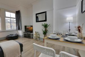 a living room with a dining table and a tv at Home from Home 4-Bed Townhouse - Ideal for Families, Groups & Contractors, Free Parking, Pet Friendly, Netflix in Walkly