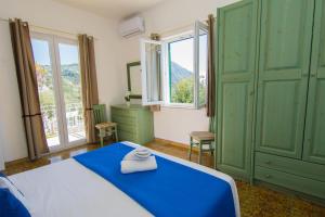 um quarto com uma cama azul e armários verdes em Lucia Maison em Ischia