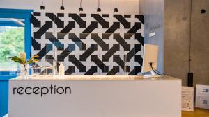 a reception counter in a room with a patterned wall at Xenia Residence & Suites in Pili