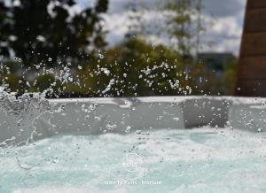 una piscina d'acqua spruzza in una vasca da bagno di Ty Puns - Gîte écoresponsable dans un espace verdoyant en centre-ville a Morlaix