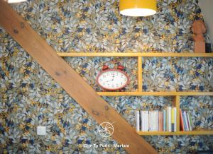 uma estante de livros com um relógio na parede em Ty Puns - Gîte écoresponsable dans un espace verdoyant en centre-ville em Morlaix