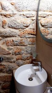 baño con lavabo blanco y pared de piedra en 200 year old 'Kamara Suite' with private garden, en Pyrgos Dirou