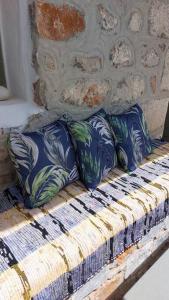 uma cama com almofadas azuis e brancas em 200 year old 'Kamara Suite' with private garden em Pirgos Dhirou