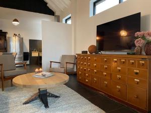 a living room with a large television on a dresser at Villa La Chatelaine in Egmond aan Zee