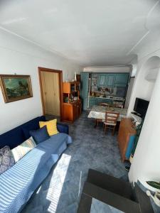 sala de estar con sofá azul y cocina en Appartamento La Follicara en Anacapri
