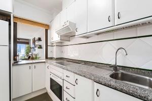 kuchnia z białymi szafkami i zlewem w obiekcie Casa Adelfas, Aguamarina w mieście Campoamor