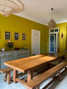 a large wooden table in a room with green walls at La ronde de Questembert in Questembert