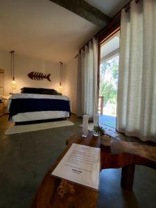 una camera con un letto e un tavolo di fronte a una finestra di Estudio Lirios seu cantinho ecológico na natureza a Marau