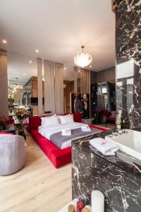 una grande camera da letto con divano rosso e vasca di ARISTO Jacuzzi Hotel a Lviv