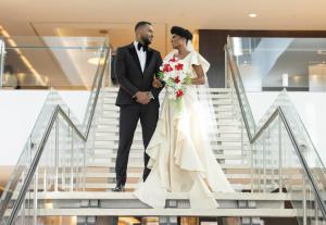 a bride and groom walking down the stairs at their wedding at EPIC SANA Luanda Hotel in Luanda