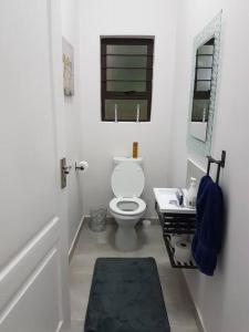 a white bathroom with a toilet and a sink at 4 Bedroom house with lovely sea views. in Ballito