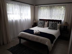 a bedroom with a large bed with pillows and windows at 4 Bedroom house with lovely sea views. in Ballito