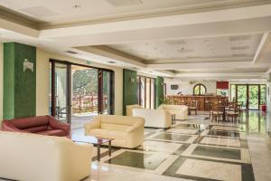 a lobby with white chairs and a dining room at Kefalonia Bay Palace in Kefallonia