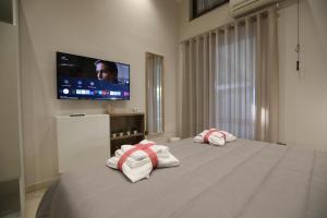 1 dormitorio con 2 toallas en una cama y TV de pantalla plana en Come a Casa Bed And Breakfast, en Boscoreale