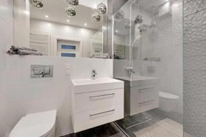 uma casa de banho branca com um lavatório e um chuveiro em Golden Apartments&Glamping-DG10 em Gdańsk