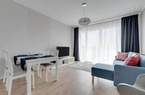 a living room with a table and a blue couch at Golden Apartments&Glamping-DG10 in Gdańsk