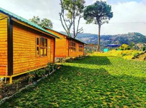 a small wooden house in a field of grass at Golden valley cottages, Chail in Chail