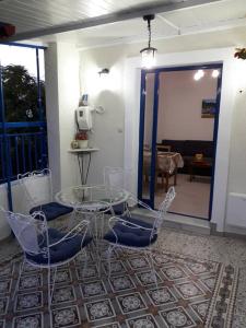 een eetkamer met een glazen tafel en stoelen bij Lovely Vacation Home in Poros