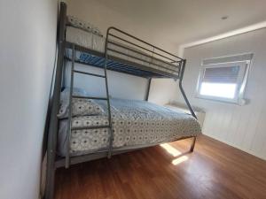 a bedroom with two bunk beds with a window at Acogedora casa con vistas panorámicas de vigo in Vigo