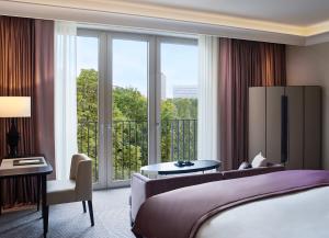 ein Hotelzimmer mit einem Bett und einem großen Fenster in der Unterkunft Sofitel Frankfurt Opera in Frankfurt am Main