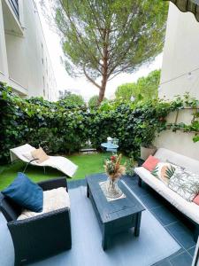 a patio with two couches and a coffee table at Havre de paix, jardin, place parking proche plage in Montpellier