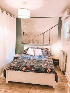 a bedroom with a bed with a floral bedspread at Havre de paix, jardin, place parking proche plage in Montpellier