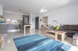 ein Wohnzimmer und eine Küche mit einem Sofa und einem Tisch in der Unterkunft New spacious apartment located in Piraeus in Piräus