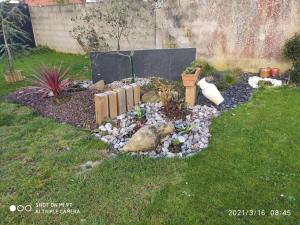 einen Garten mit Felsen und Pflanzen im Hof in der Unterkunft TY BIHAN in La Bernerie-en-Retz