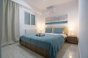 ein Schlafzimmer mit einem großen Bett mit einer blauen Decke in der Unterkunft New spacious apartment located in Piraeus in Piräus