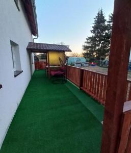 a deck with green grass and a gazebo at Agroturystyka u Rolnika - Apartament in Stare Nowakowo