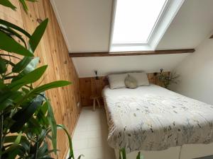 a small bedroom with a bed and a window at B & B 'Droom in de polder de Suite met prive sauna in Arnemuiden